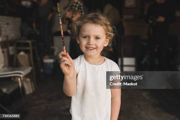 portrait of girl showing magic wand in storage room - wand 個照片及圖片檔