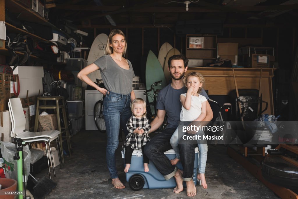 Portrait of parents and children in storage room of house