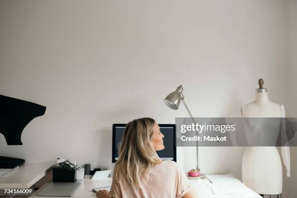 rear view of female design professional using computer at home - mannequin blonde stockfoto's en -beelden