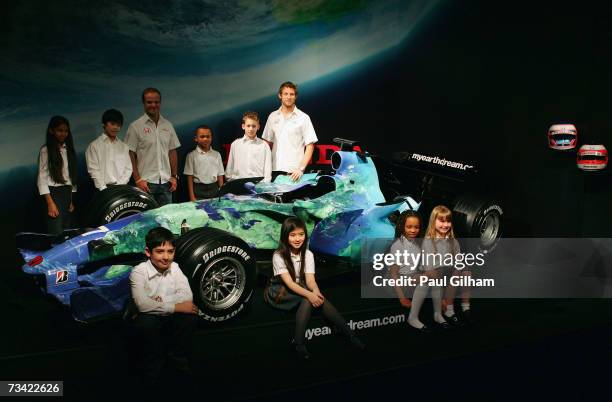 Jenson Button of Great Britain and Honda Racing and Rubens Barrichello of Brazil and Honda Racing pose together with some local school children...