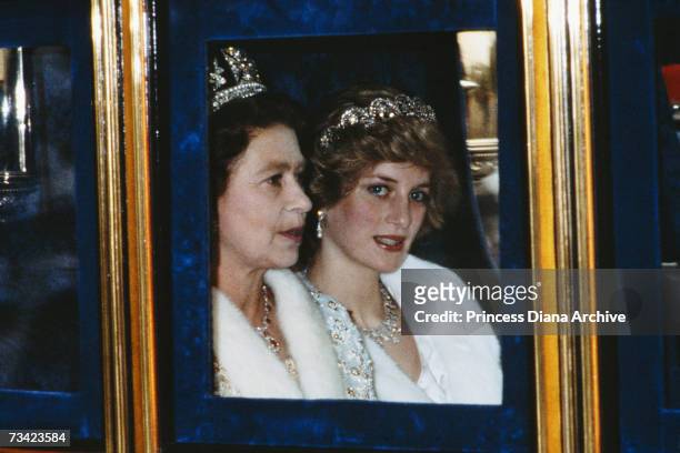The Princess of Wales and the Queen attend the Opening of Parliament in London, November 1982. Diana is wearing a white fur coat and the Spencer...