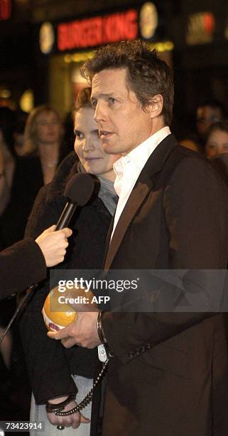 Amsterdam, NETHERLANDS: A female fan of British actor Hugh Grant stands next to him after breaking through the security to shake his hand and...