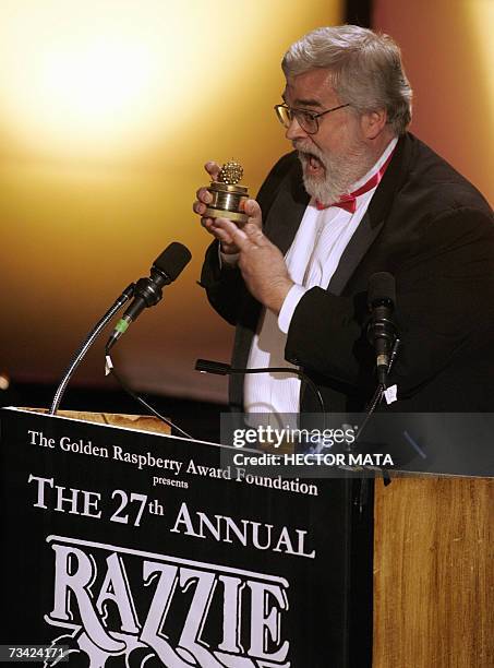 Hollywood, UNITED STATES: The creator of the "Razzie Awards", cinema aficionado John Wilson, displays the trophy that will be distributed during the...