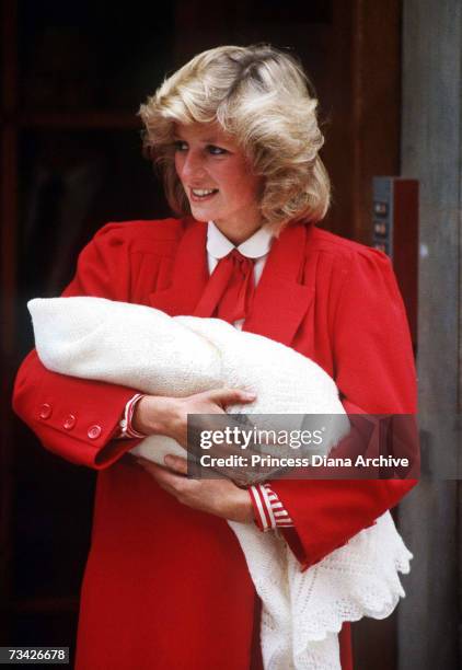 Princess Diana leaving St Mary's Hospital, London with her new-born son Prince Harry, 16th September 1984. She is wearing a red coat by Jan van...