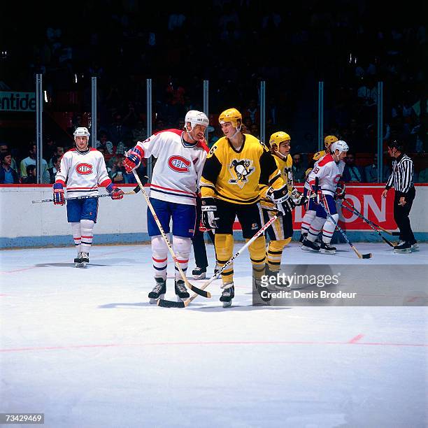 Mario Lemieux of the Pittsburgh Penguins shares a laugh with Larry Robinson of the Montreal Canadiens during the game