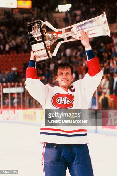 Guy Carbonneau of the Montreal Canadiens hoists the Prince of Wales Trophy over his head after defeating the Los Angeles Kings in the Stanley Cup...