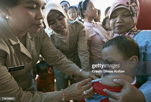 An Indonesian health worker vaccinates an Indonesian child against measles February 27, 2007 in Jakarta, Indonesia. Indonesia launched a campaign...