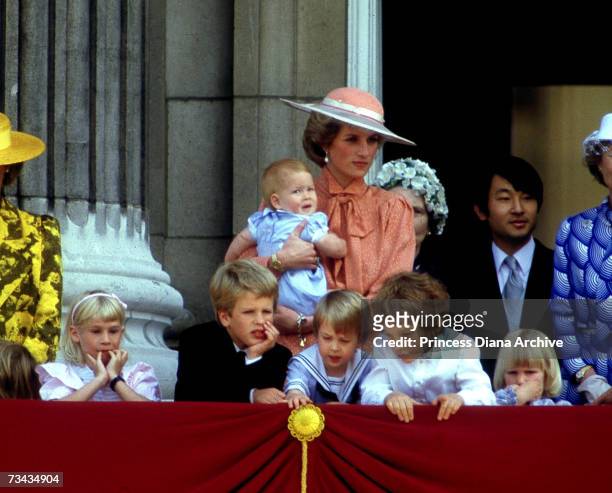 Princess Diana holds her son Prince Harry as she watches the Trooping of the Colour from the balcony of Buckingham Palace, London, June 1985. On the...