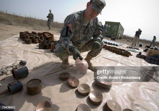 Army soldier displays a large weapons cache of deadly armor-piercing bombs of a type Tehran has allegedly smuggled to Shiite militias, February 26,...