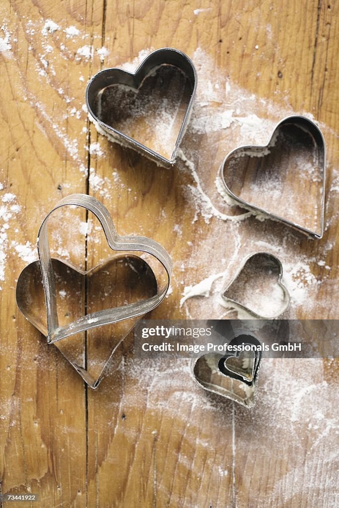 Heart-shaped biscuit cutters on floured board