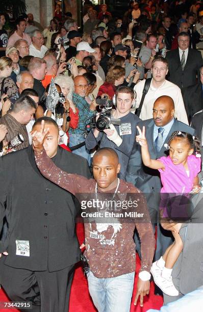Boxer Floyd Mayweather Jr. And his daughter Iyanna Mayweather signal to fans as he arrives for a news conference at the MGM Grand Hotel/Casino as...