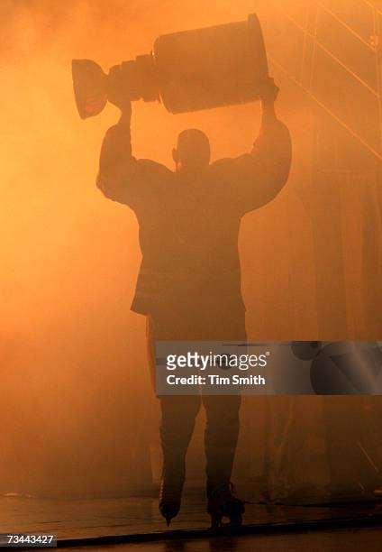 Former Edmonton Oilers great Mark Messier is silhouetted as he hoists the Stanley Cup while skating onto the ice during a ceremony to raise his...