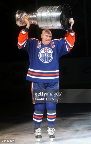Former Edmonton Oilers great Mark Messier hoists the Stanley Cup while skating across the ice during a ceremony to raise his banner to the rafters of...
