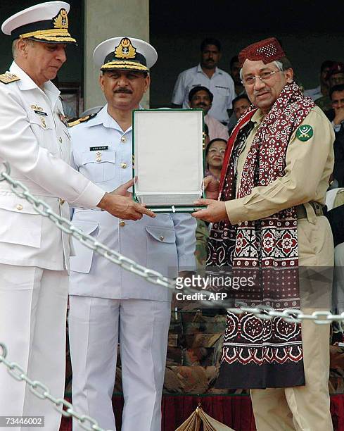 Pakistani President Pervez Musharraf wears a traditional Sindhi shawl and cap as he receives a shield from Commodore Abid Saleem , the principal of...
