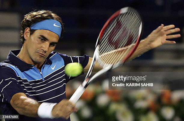 Dubai, UNITED ARAB EMIRATES: Swiss player Roger Federer returns the ball to Italy's Daniele Bracciali during their ATP Dubai Duty Free Open tennis...