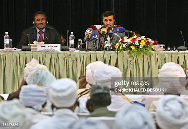 Iranian President Mahmoud Ahmadinejad delivers a speech as he sits next to Sudanese Minister of Religious affairs and Waqf Azhari al-Tigani al-Sid...
