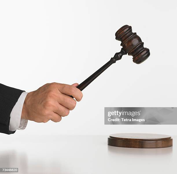 close up studio shot of judge's hand with gavel - judge hammer stock pictures, royalty-free photos & images