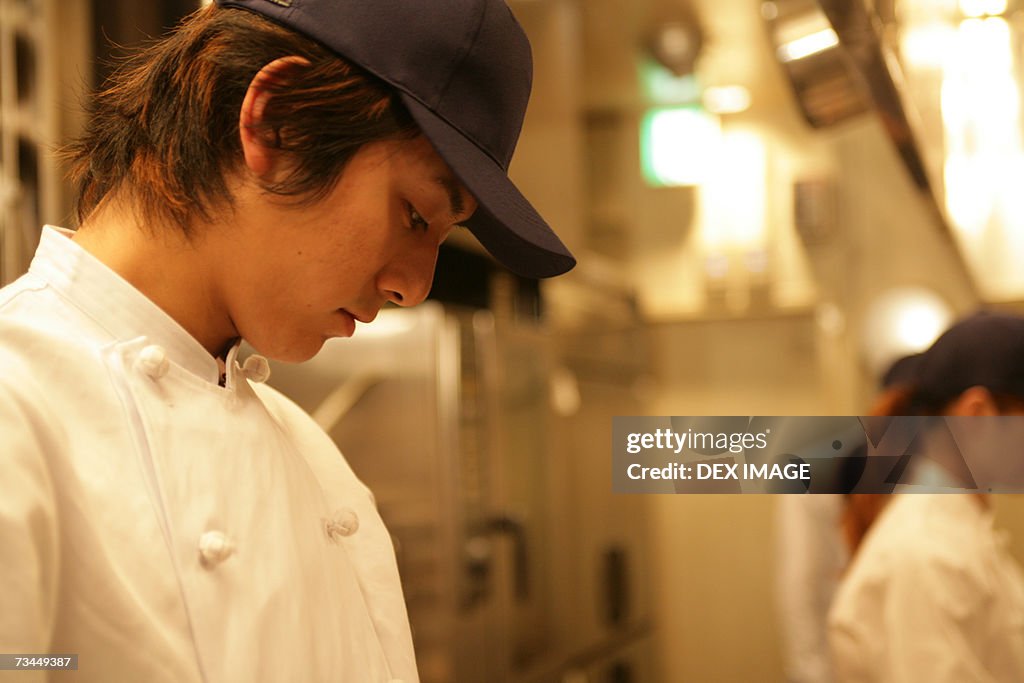 Side profile of a male chef looking down