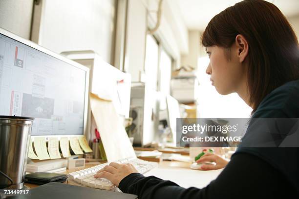 side profile of a businesswoman working on a computer - etnia indo asiatica fotografías e imágenes de stock