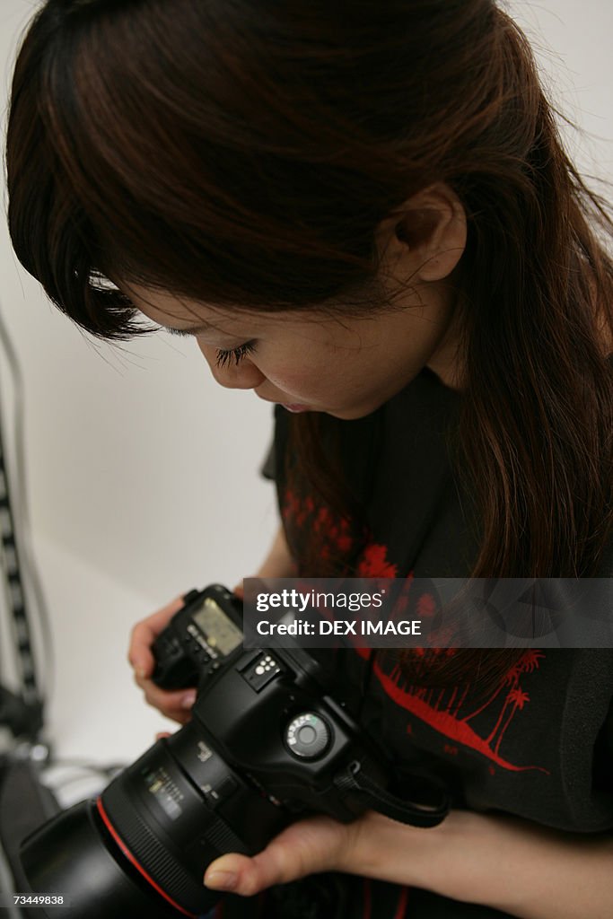 Close-up of a young woman holding a camera