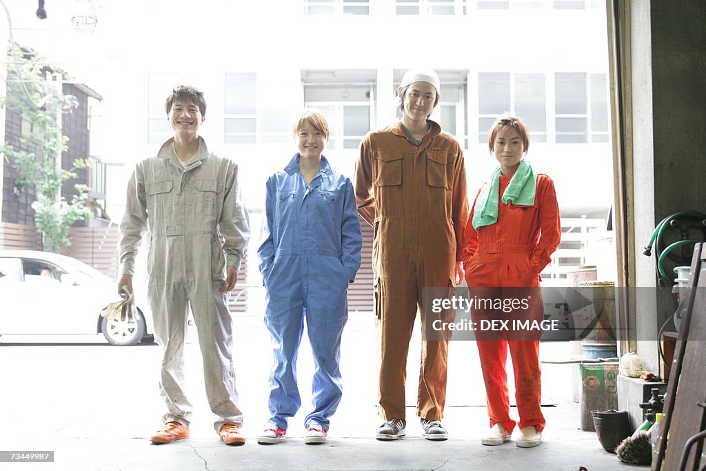 Portrait of four auto mechanics standing in an auto repair shop