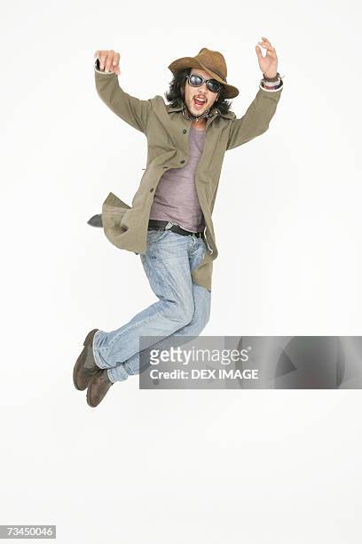 young man jumping - long coat 個照片及圖片檔