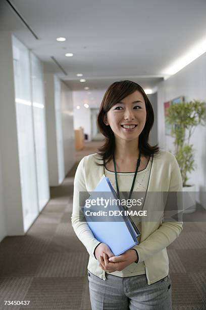 close-up of a businesswoman carrying a file and looking cheerful - japanese bussiness woman looking up imagens e fotografias de stock