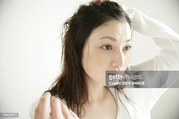 close-up of a young woman looking away - 髪に手をやる　女性 ストックフォトと画像