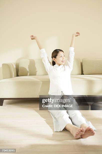 young woman sitting on the floor and smiling - pj soles stock pictures, royalty-free photos & images