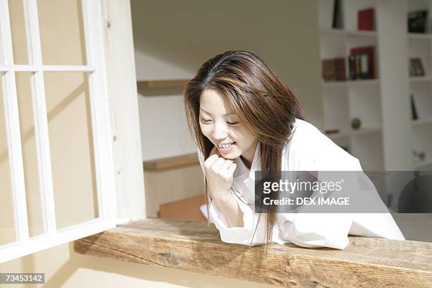 young woman bending over a window - stack of sun lounges stock pictures, royalty-free photos & images