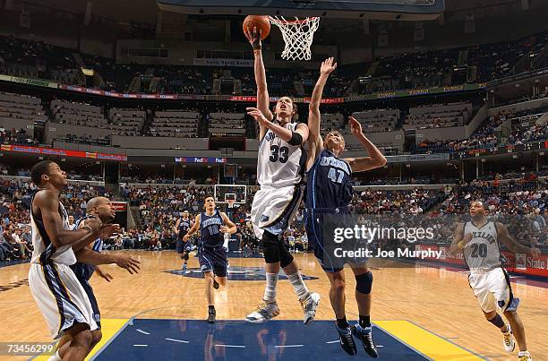 Mike Miller of the Memphis Grizzlies shoots a layup past Andrei Kirilenko of the Utah Jazz on February 28, 2007 at FedExForum in Memphis, Tennessee....
