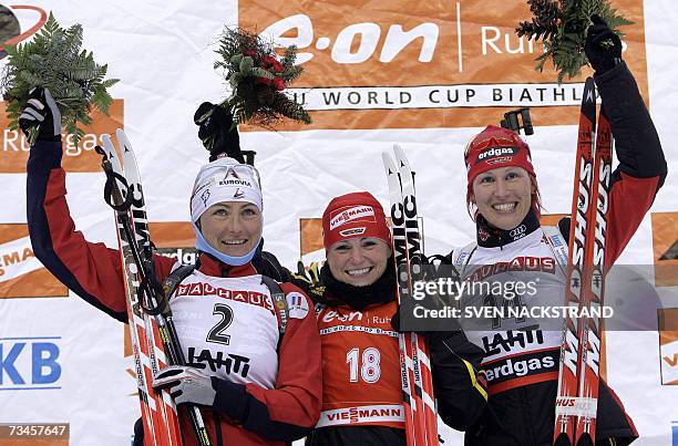 Lahti , FINLAND: Andrea Henkel of Germany celebrates on the podium with France's Florence Baverel-Robert and Germany's Kati Wilhelm after winning the...