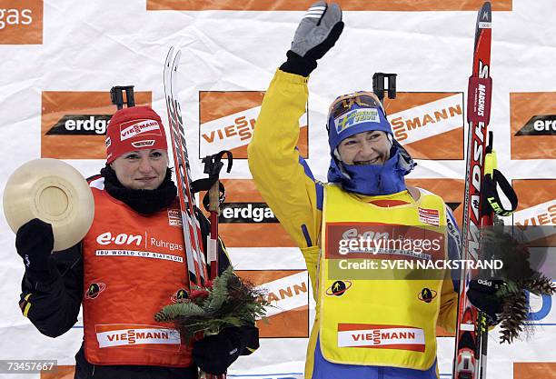 Lahti , FINLAND: Sweden's Anna Carin Olofsson waves to supporters next to winner of the IBU Womens' 15 km Biathlon Andrea Henkel of Germany 28...