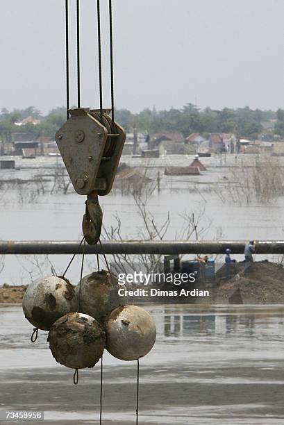 March 1: Indonesian workers drop chained concrete balls to help stem mudflow, March 1, 2007 in Sidoarjo, East Java, Indonesia. Over the next few...