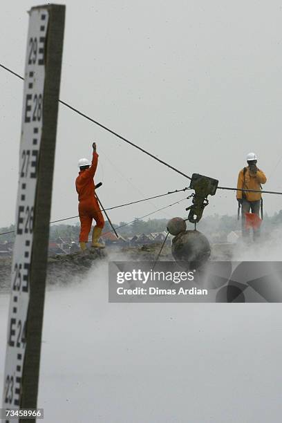 March 1: Indonesian workers drop chained concrete balls to help stem mudflow, March 1, 2007 in Sidoarjo, East Java, Indonesia. Over the next few...