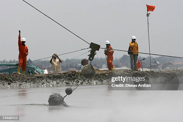 Indonesian workers drop chained concrete balls to help stem mudflow, March 1, 2007 in Sidoarjo, East Java, Indonesia. Over the next few weeks,...