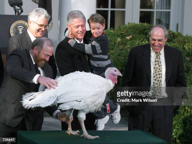 President Bill Clinton, holding his nephew Tyler, smiles after granting a Thanksgiving pardon to a turkey named Jerry, November 22, 2000 in the Rose...