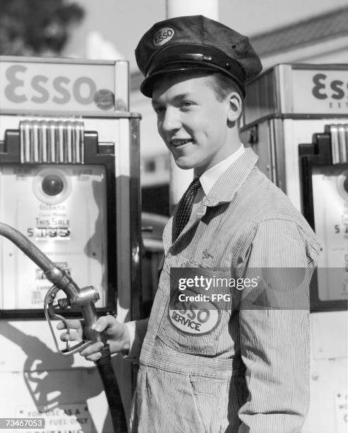 Petrol pump attendant at an Esso station, circa 1955.