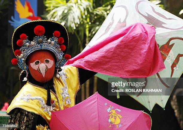 An artist performs an ancient oriental art of mask changing at the Jurong BirdPark in SIngapore 23 February 2007. The 26-year old artist from Herbei,...
