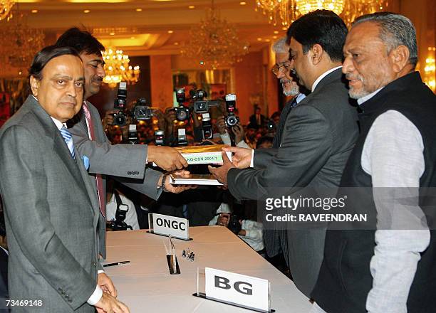 Indian Petroleum and Natural Gas Minister, Murali Deora and his Minister of State for Petroleum and Natural Gas, Dinsha Patel watch as officials from...