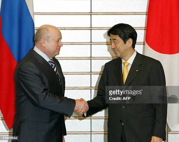 Russian Prime Minister Mikhail Fradkov shakes hands with Japanese Prime Minister Shinzo Abe at the start of their meeting at the prime minister's...