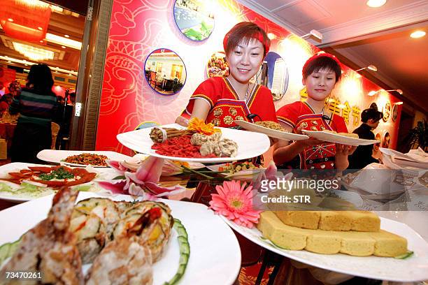 Chinese waitresses show off the various Taiwanese dishes at a Taiwan food fair, ahead of annual session of the National People's Congress in Beijing...
