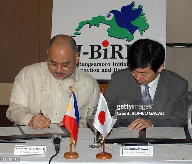 Silvestre Afable , chairman of the Philippine government negotiating panel and Kenji Maekawa , Japan mission leader for Mindanao signs the study for...