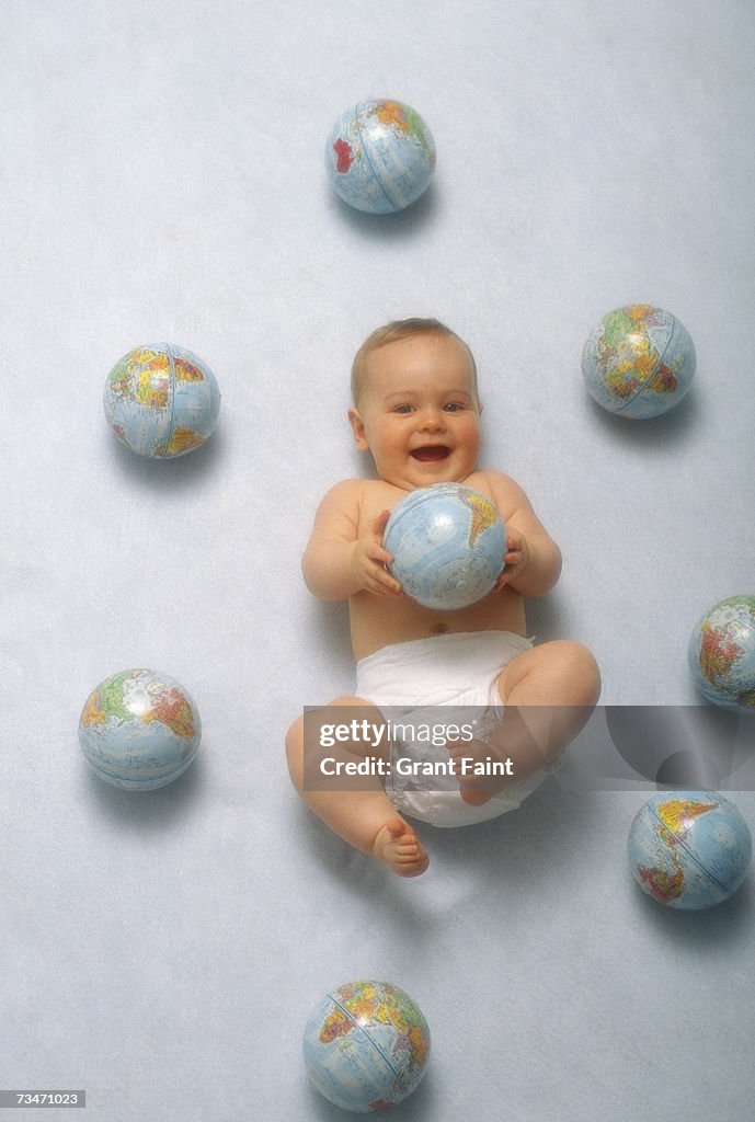 Baby (6-12 months) lying with globes