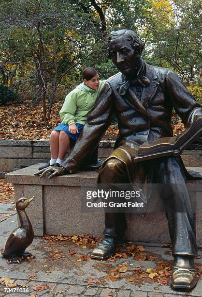 teenage girl (16-17) sitting by statue of hans christian anderson - hans christian andersen ストックフォトと画像