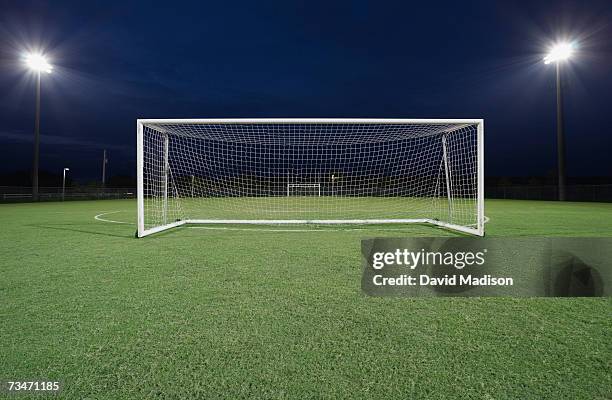 soccer goal on field at night - soccer goal stock-fotos und bilder