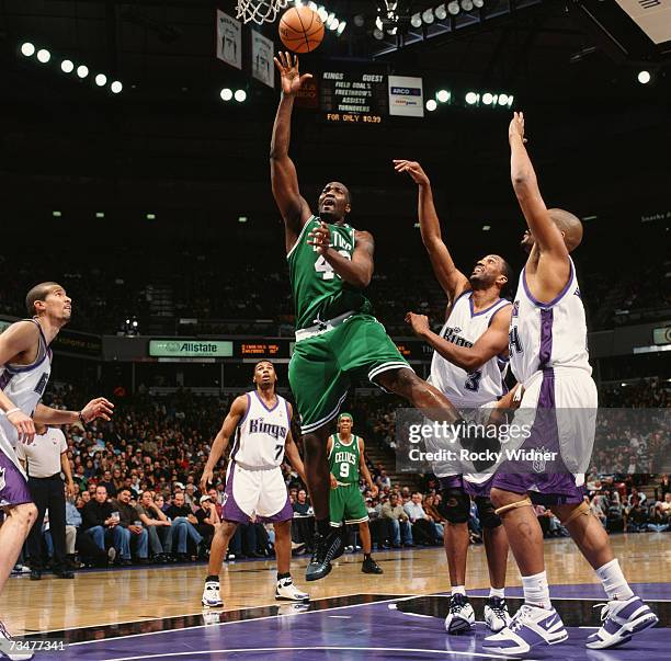 Kendrick Perkins of the Boston Celtics shoots a layup against Shareef Abdur-Rahim and Corliss Williamson of the Sacramento Kings during a game at...
