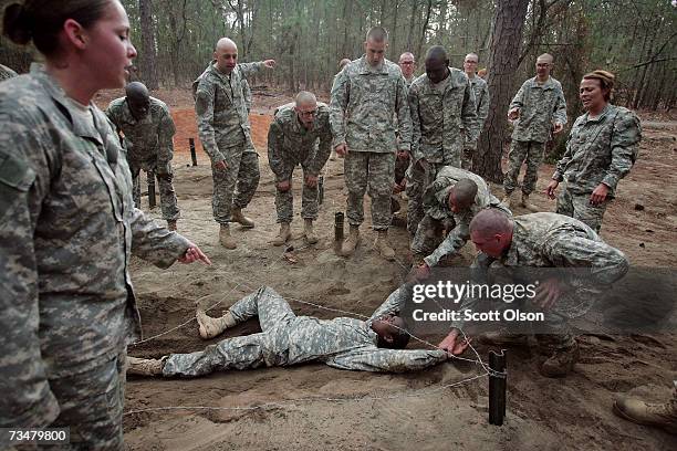 Shalish Grant of Jersey City, New Jersey is helped through an obstacle course during Army basic training at Fort Jackson March 1, 2007 in Columbia,...