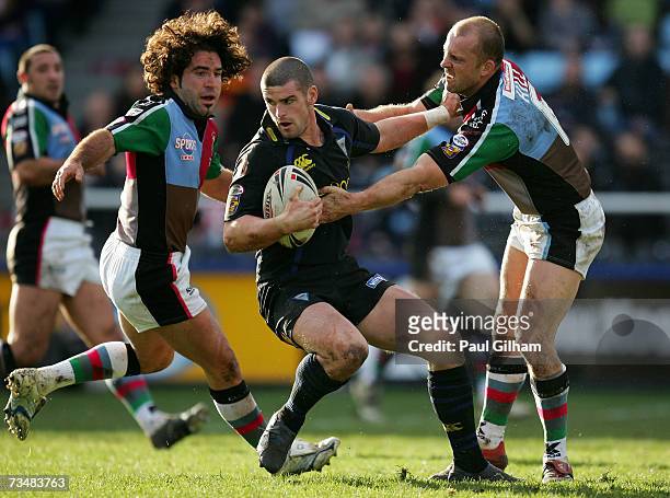 Stuart Reardon of Warrington Wolves is challenged by Scott Hill and Julien Rinaldi of Harlequins during the Engage Super League match between...