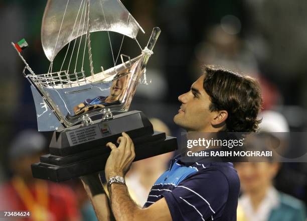 Dubai, UNITED ARAB EMIRATES: Roger Federer of Switzerland holds his trophy after beating Mikhail Youzhny of Russia in their final tennis match for...